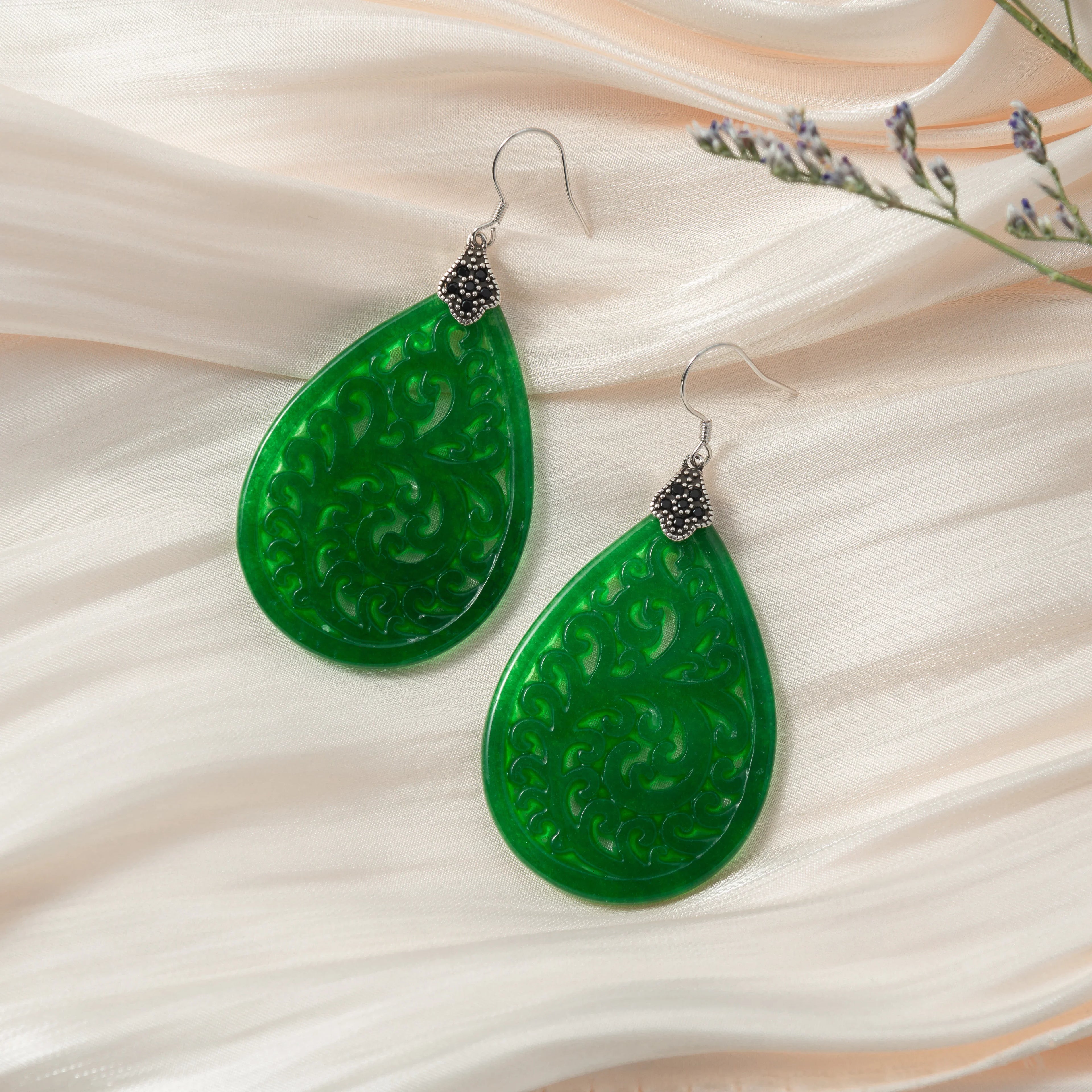 Lace-inspired 925 silver earrings with dark green jade teardrops in traditional Chinese style on a silk cloth