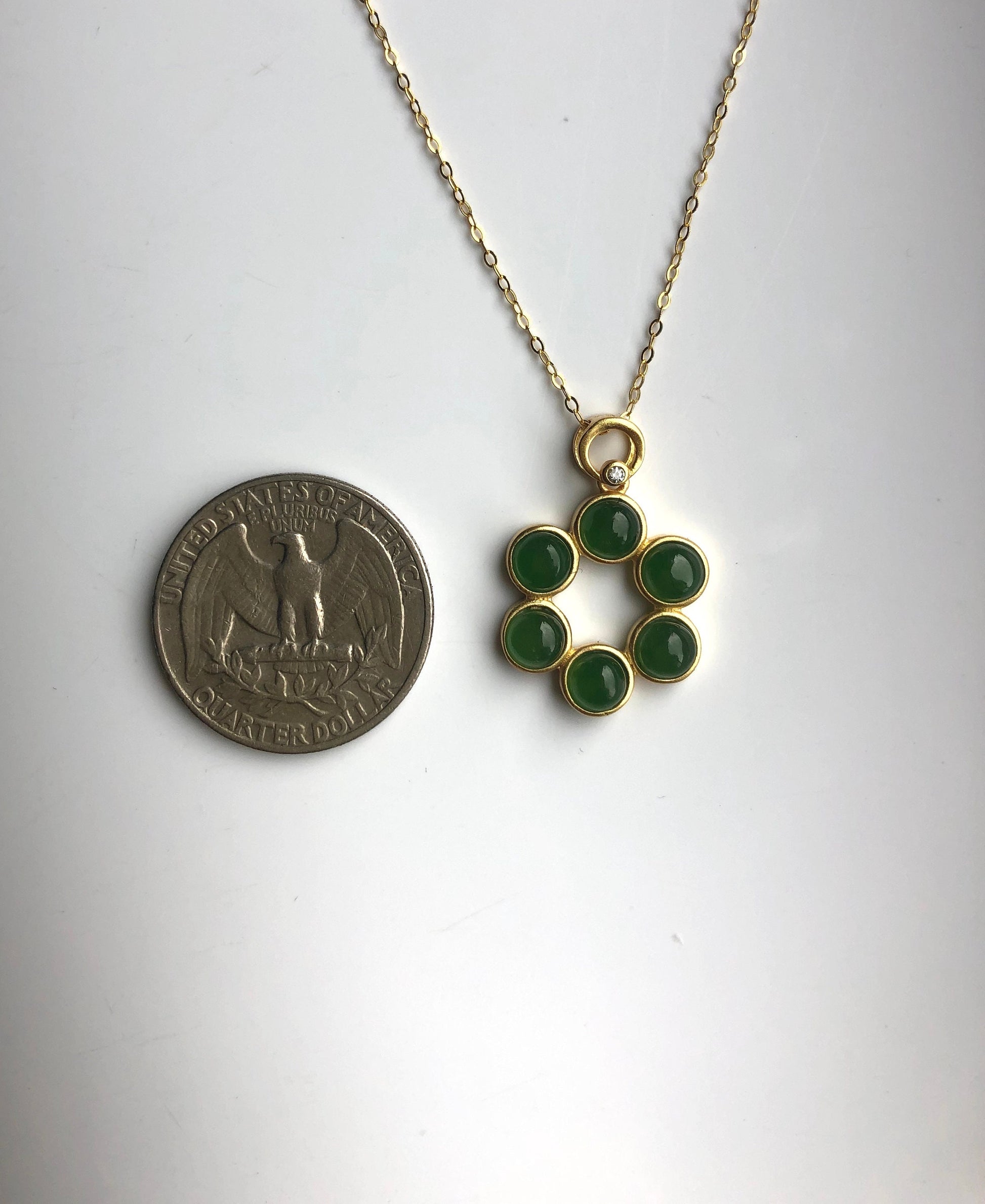Size comparison of jade pendant next to a coin