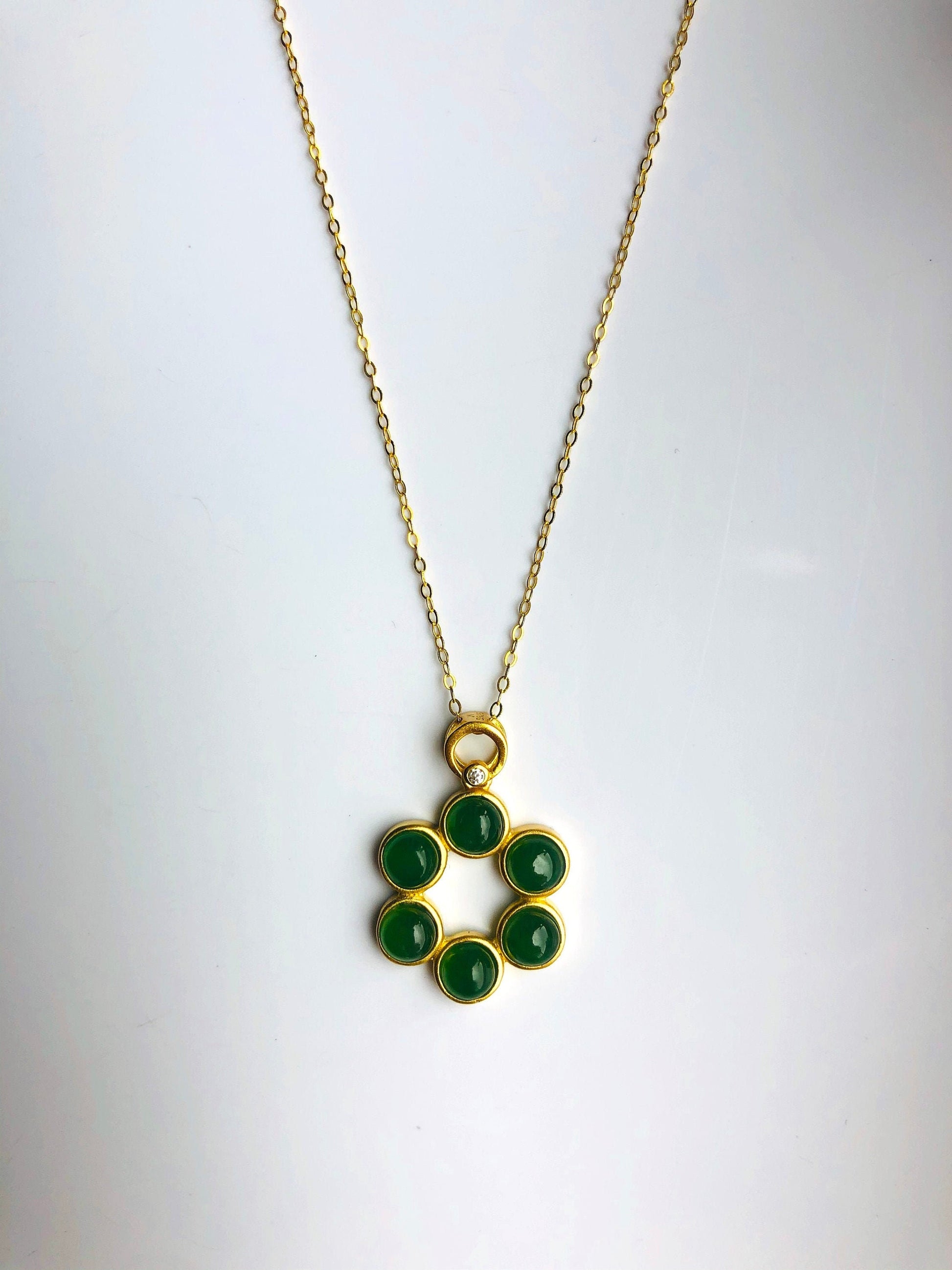 An 18k gold plated hexagonal pendant necklace with natural green jade beads and a star pattern.