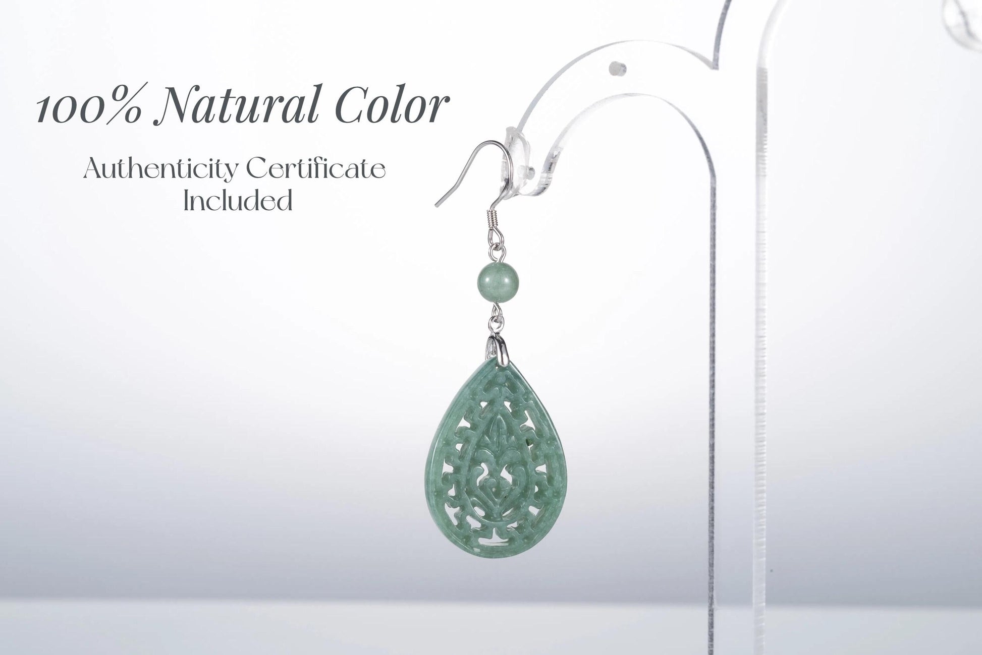 Close-up of authentic jade teardrop earrings with intricate silver vintage frame