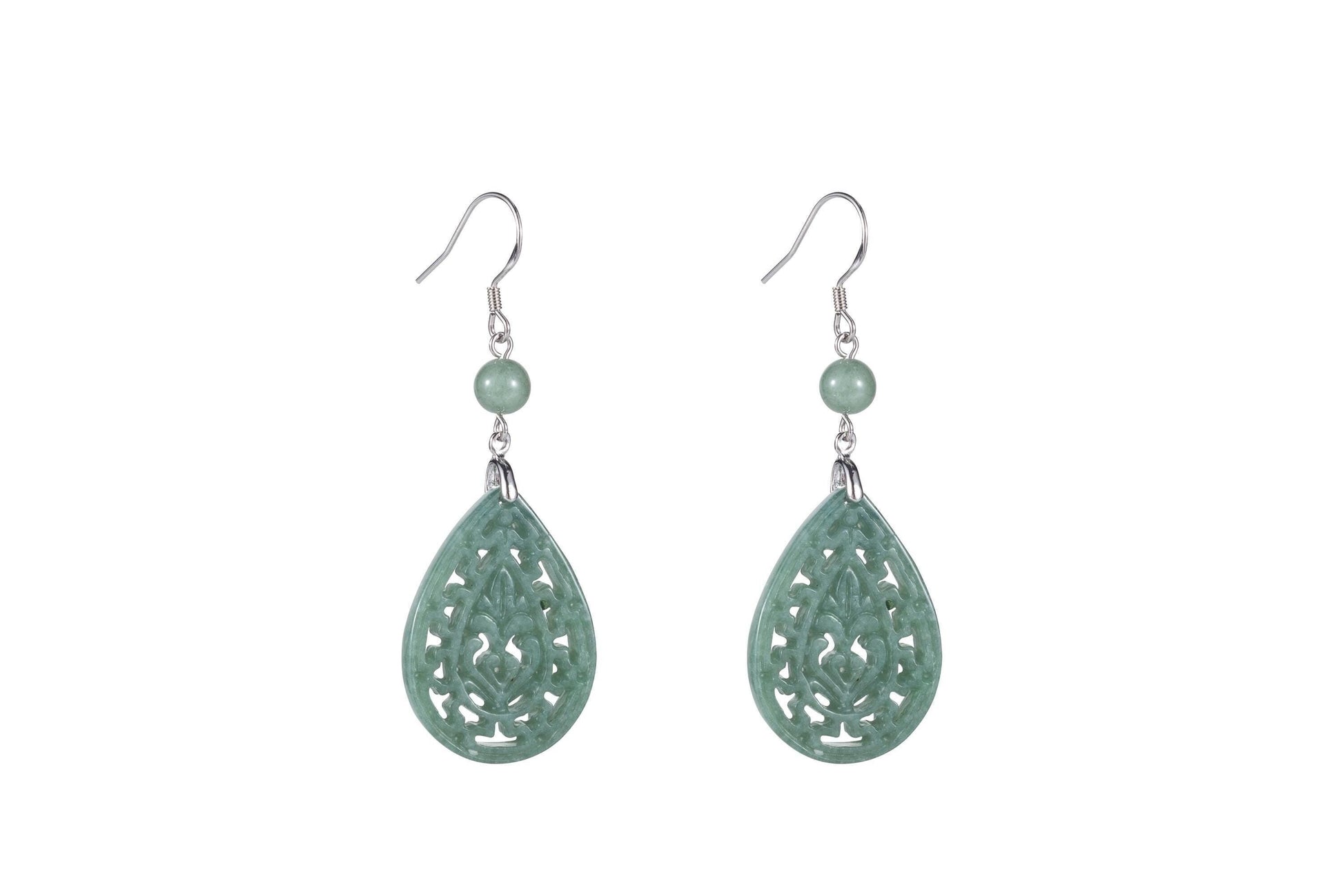 A pair of light green jade teardrop earrings with intricate cut-out patterns, suspended from silver hooks.