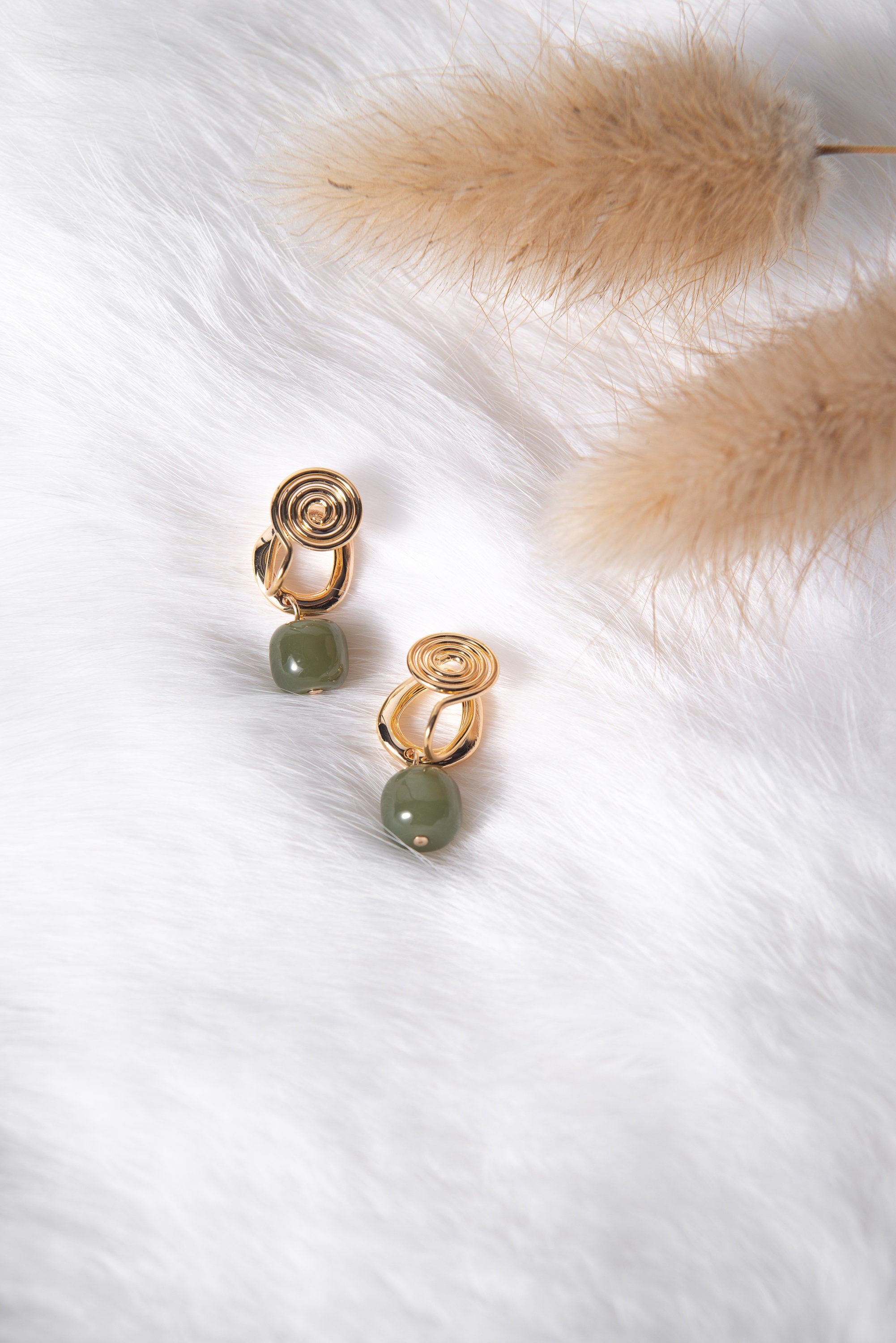 Close-up of genuine green jade clip-on earrings showing natural jade texture and gold details