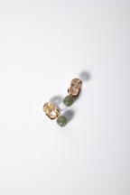 side angle of hanging green jade clip-on earrings showing natural jade texture and gold details