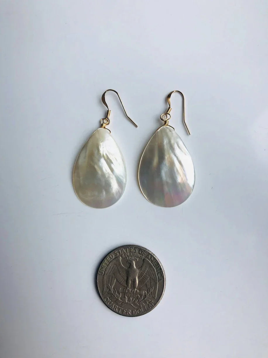 Teardrop-shaped earrings on a light gray background with a coin for scale.