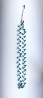 full angle of raw turquoise seed bead necklace with organic red coral accents