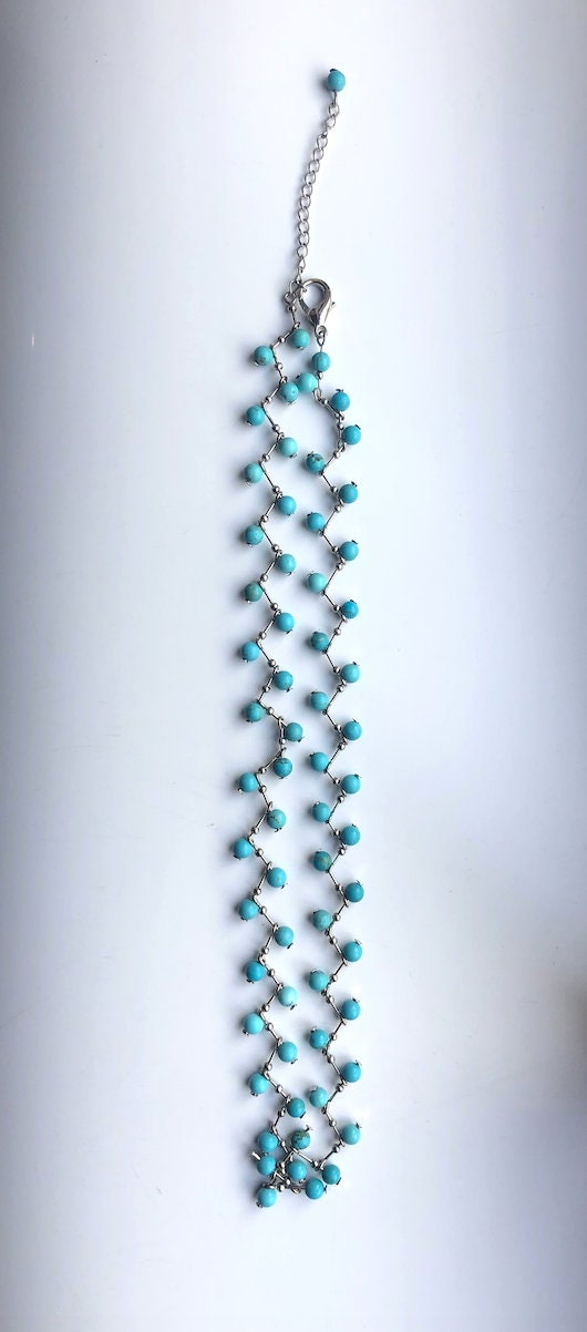 full angle of raw turquoise seed bead necklace with organic red coral accents