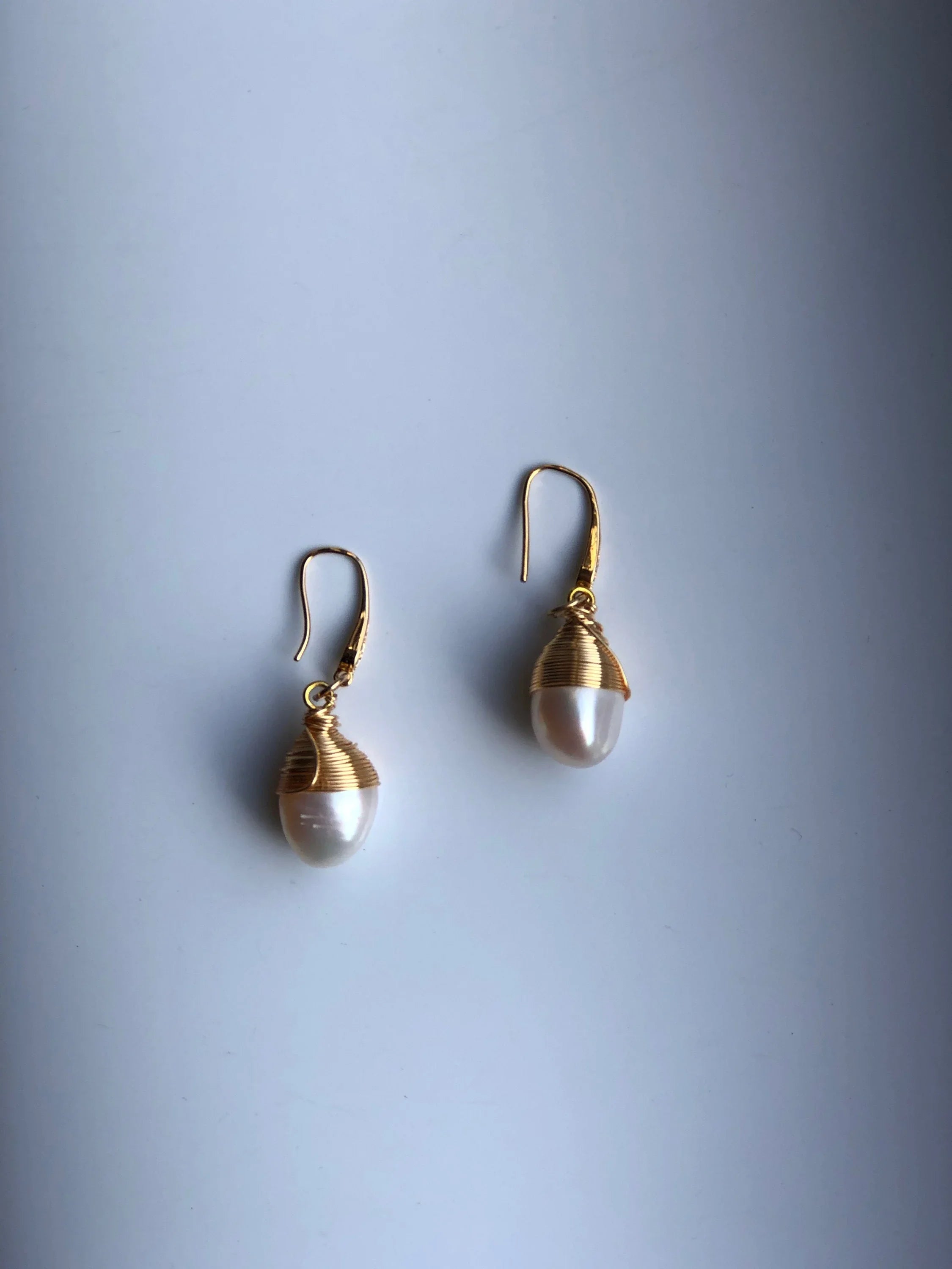 A pair of baroque-style real pearl earrings with 14k gold wire wrapping, displayed against a neutral background.