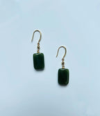 Side angle showing cube-shaped jade drop earrings with gold detail