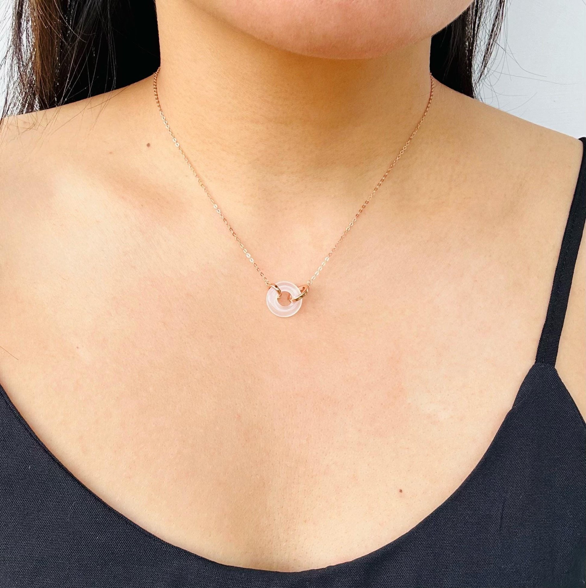 Model wearing 18" rose gold necklace with round white jade pendant

