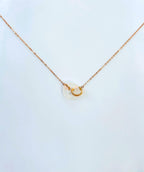 Side angle showing polished white jade circle pendant and rose gold chain

