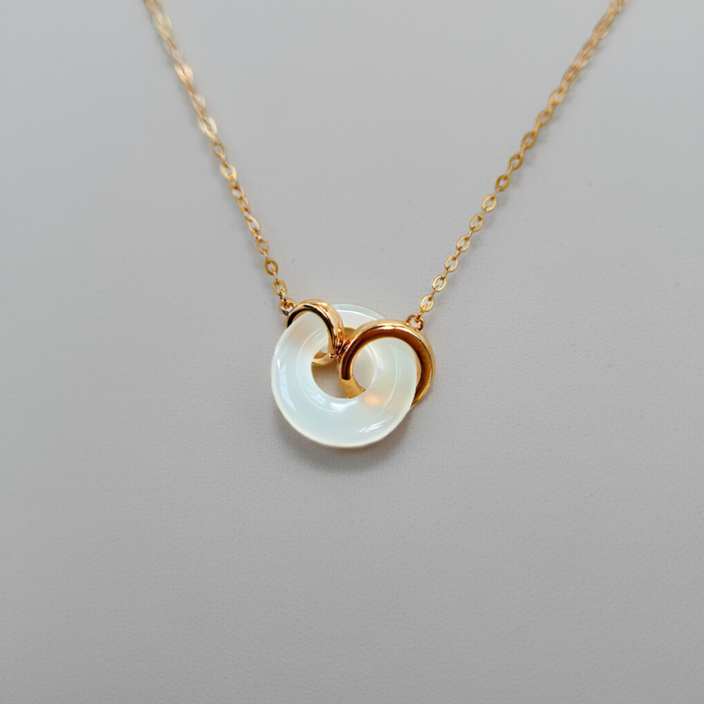 Rose gold white jade pendant necklace against light grey background