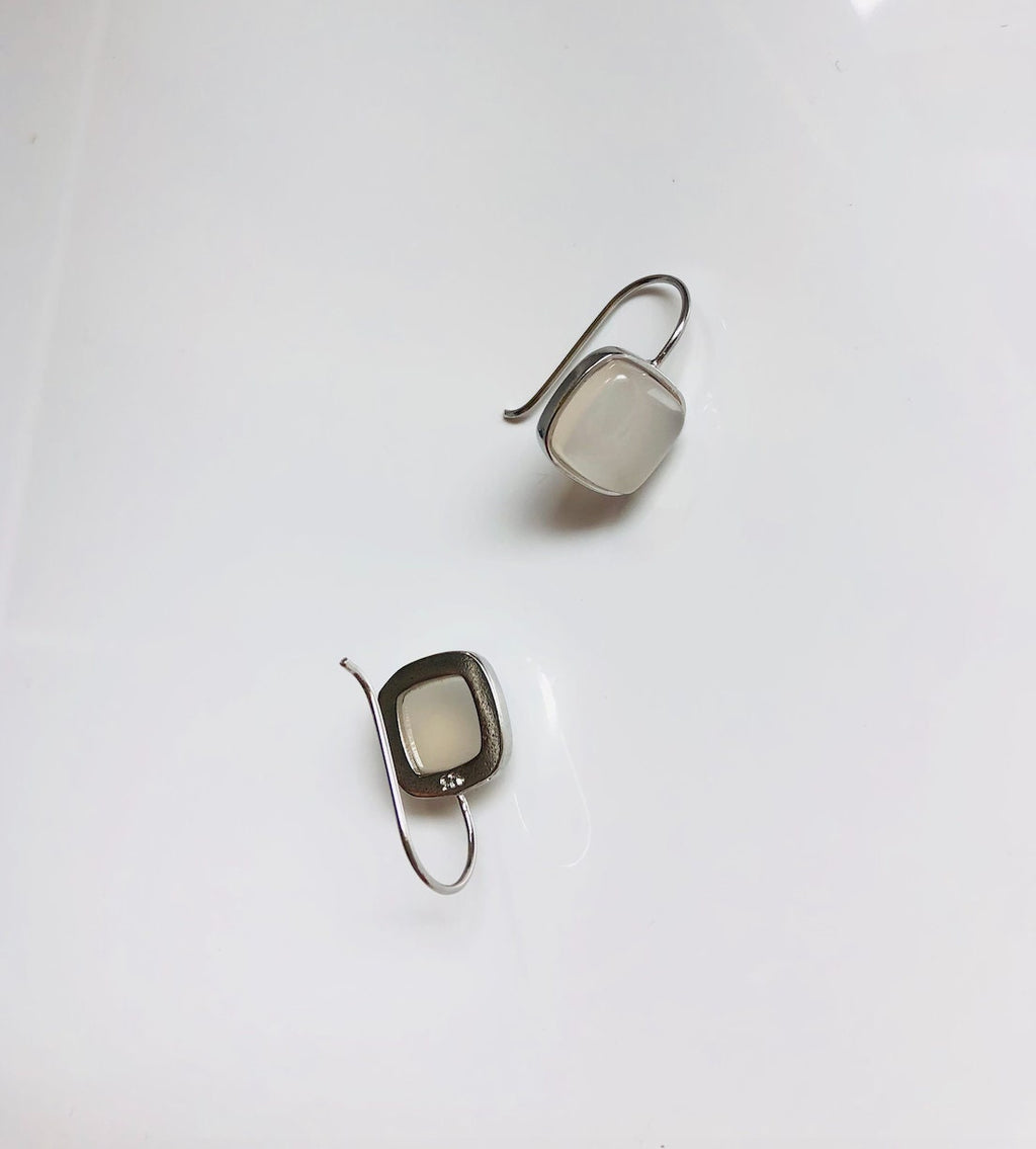 back view of white jade square dangle earrings hanging from polished 990 silver hooks