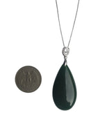 Teardrop-shaped green pendant on a chain with a coin for scale on a white background