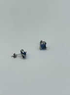 Back view of small silver snake eye studs with deep blue topaz-style gemstone center