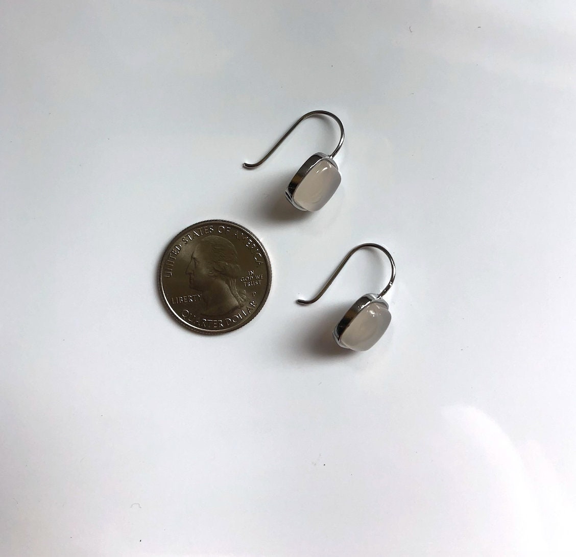 White jade square earrings placed next to US quarter coin for size reference