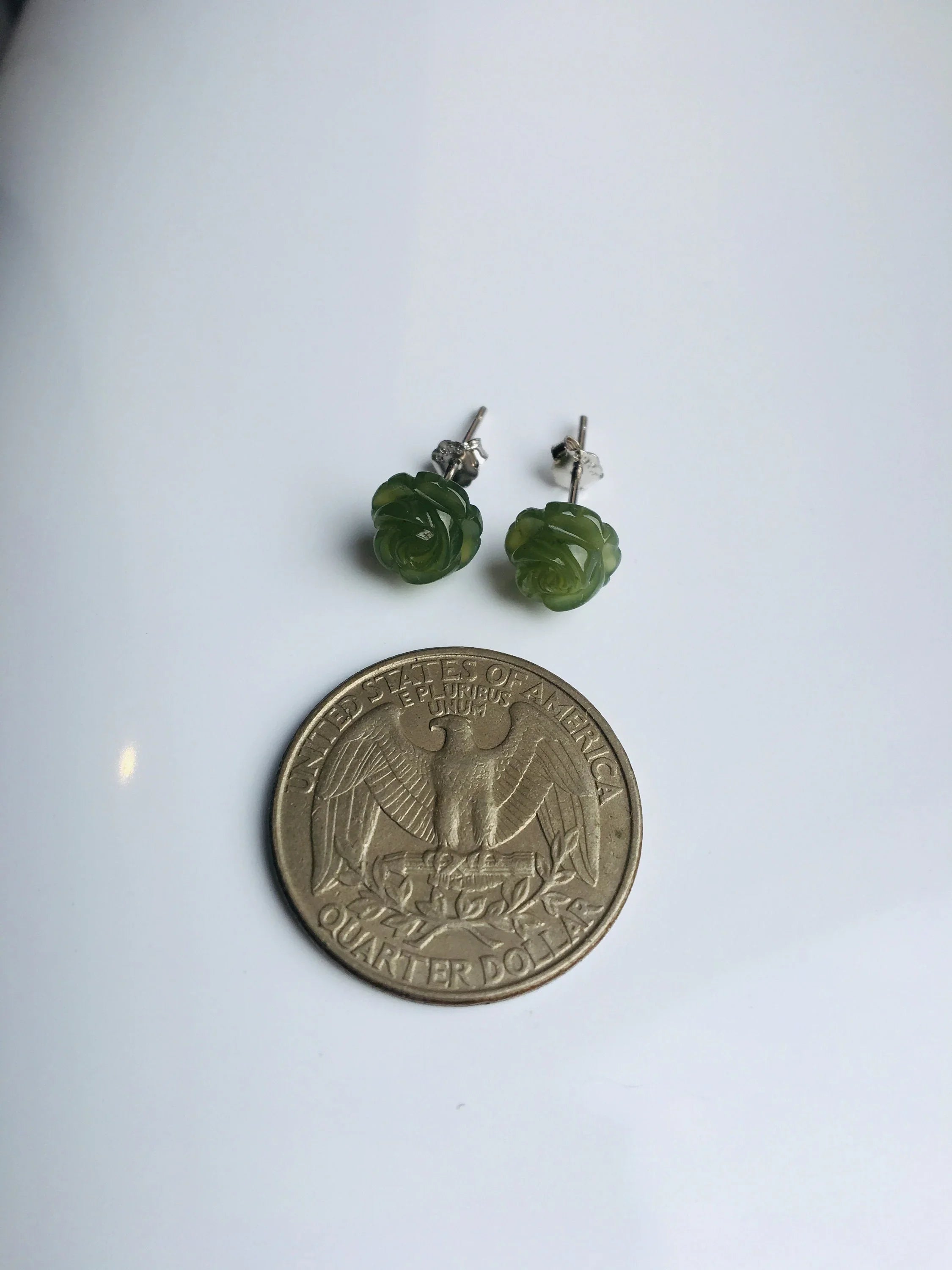Small jade stud earrings shown next to a US quarter coin for size comparison