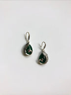 Side angle of silver peacock earrings with dark green jade teardrop stones