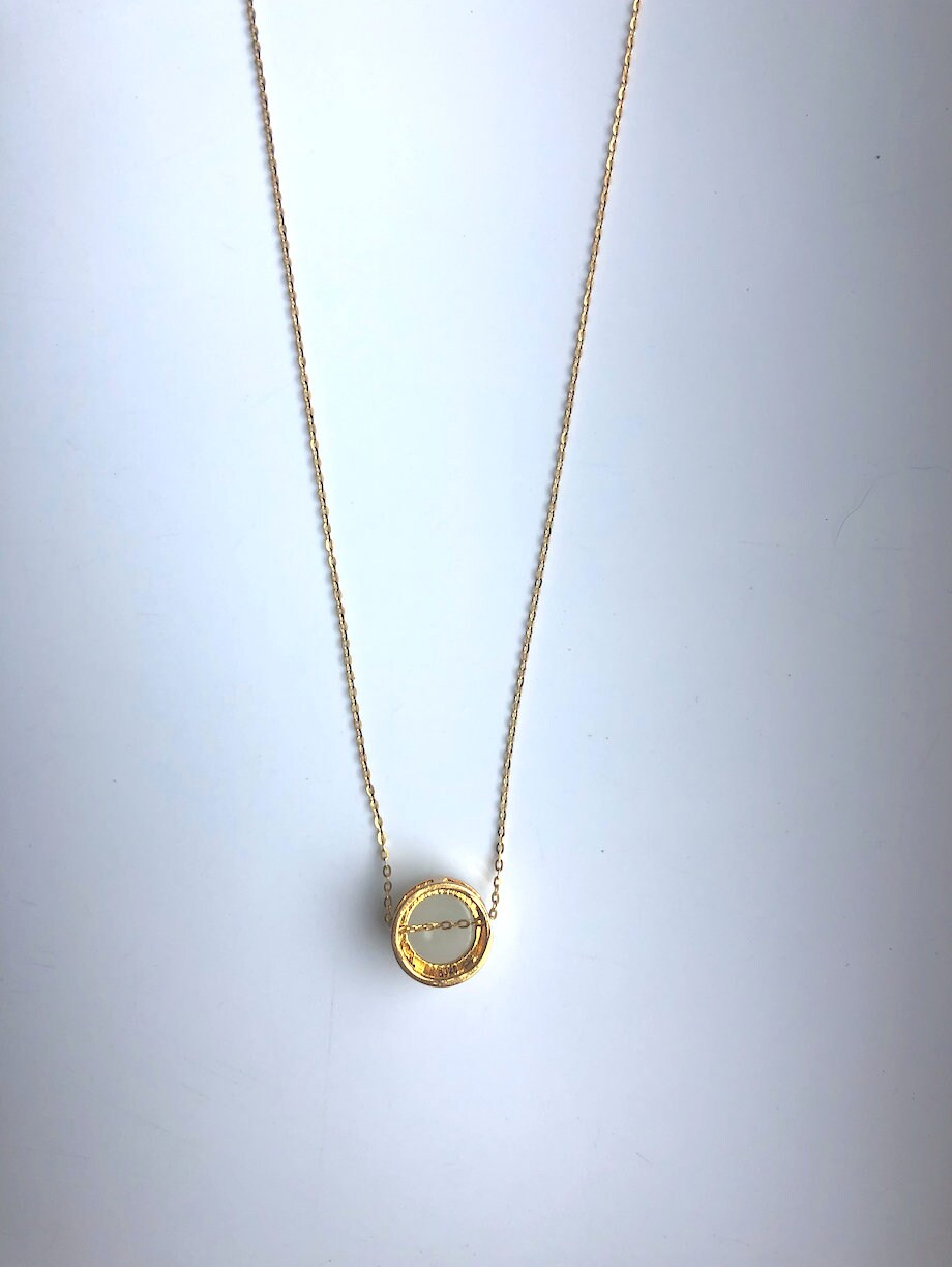 Back view of white jade charm showing stone texture and chain clasp