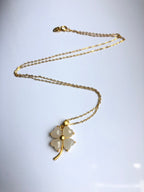 a full view showing white jade clover pendant and delicate gold chain

