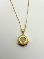 Back of white jade pendant showing smooth finish, S925 mark and gold setting

