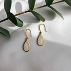 Front view of 18k gold white jade teardrop earrings with minimalist design

