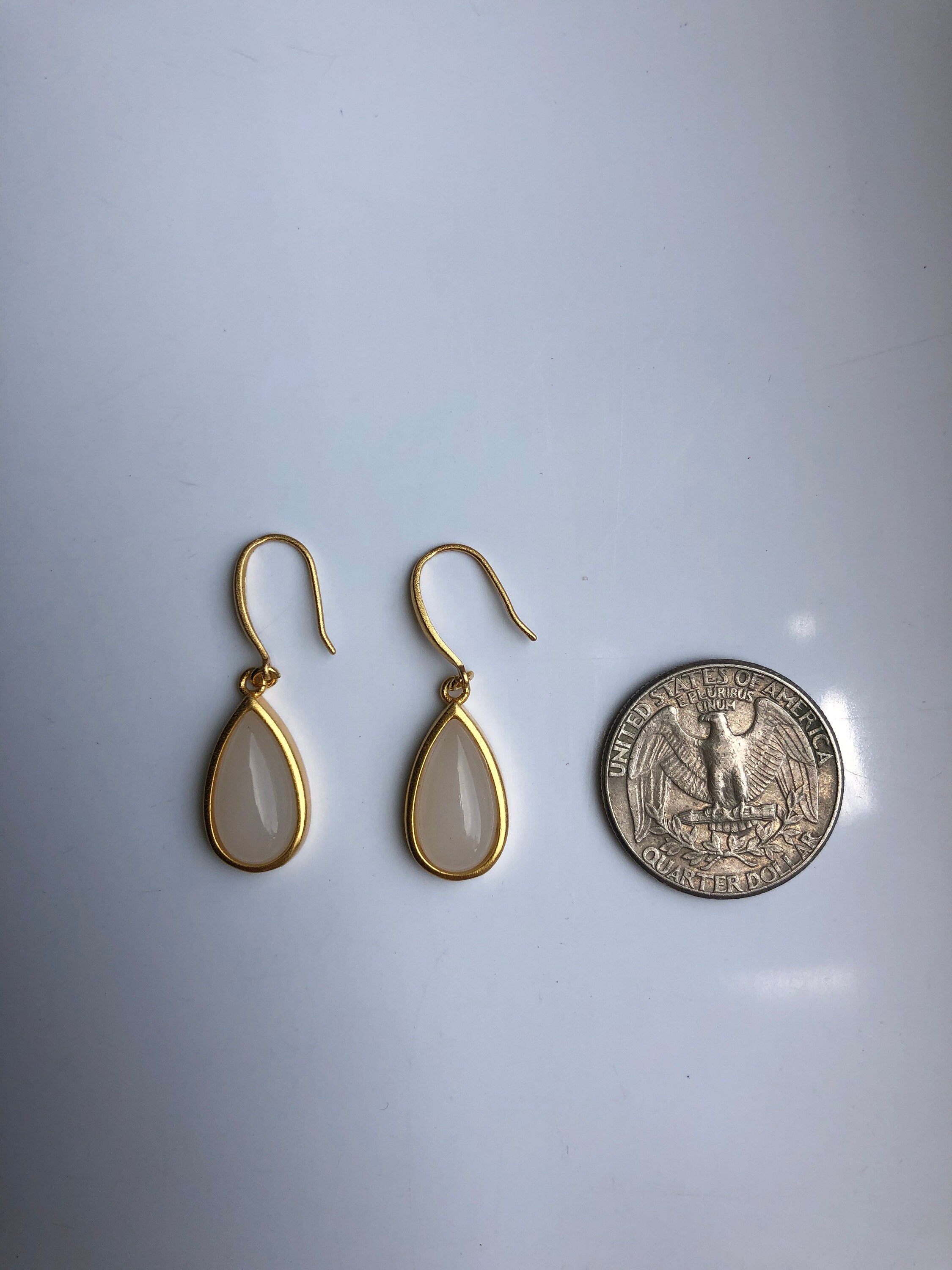 White jade earrings shown next to coin for teardrop size reference

