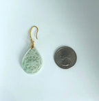 Green teardrop earring with gold hook on a white background, next to a quarter for scale.