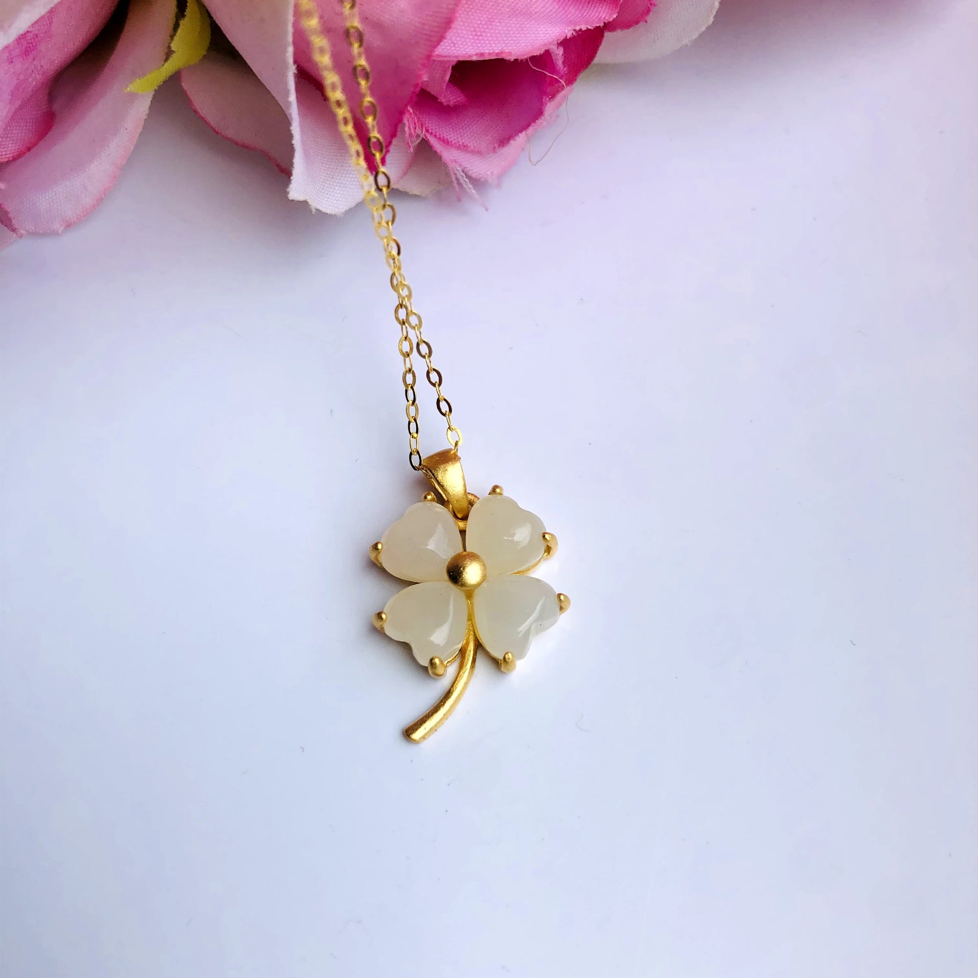white jade clover pendant with pink rose background